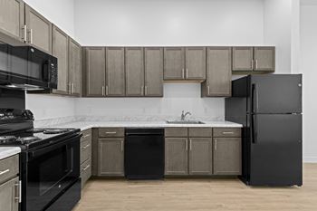 Kitchen with black appliances and brown cabinets at 36N Apartments, Tulsa, OK, 74106